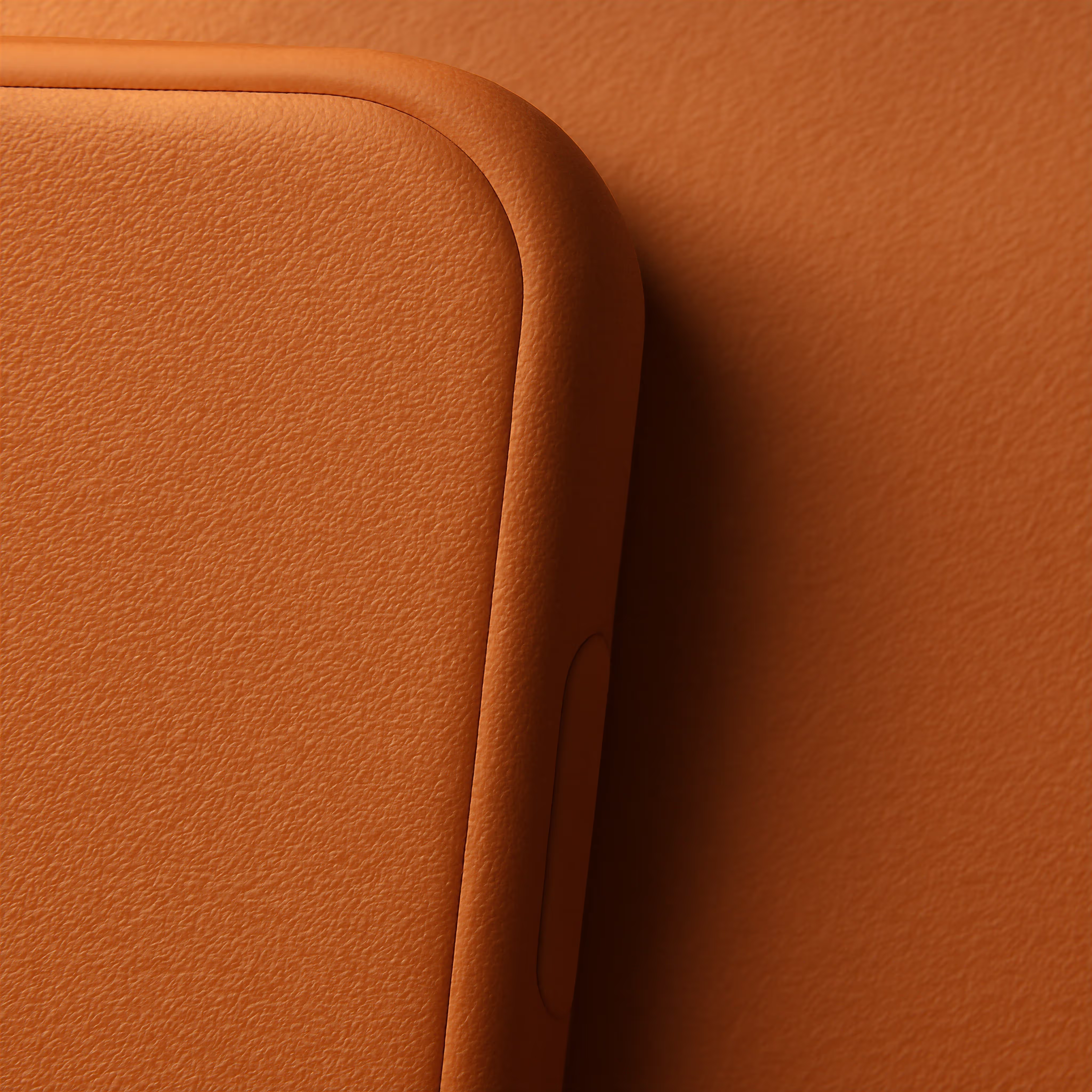 Close-up of a rounded corner of a brown leather phone case with textured surface.