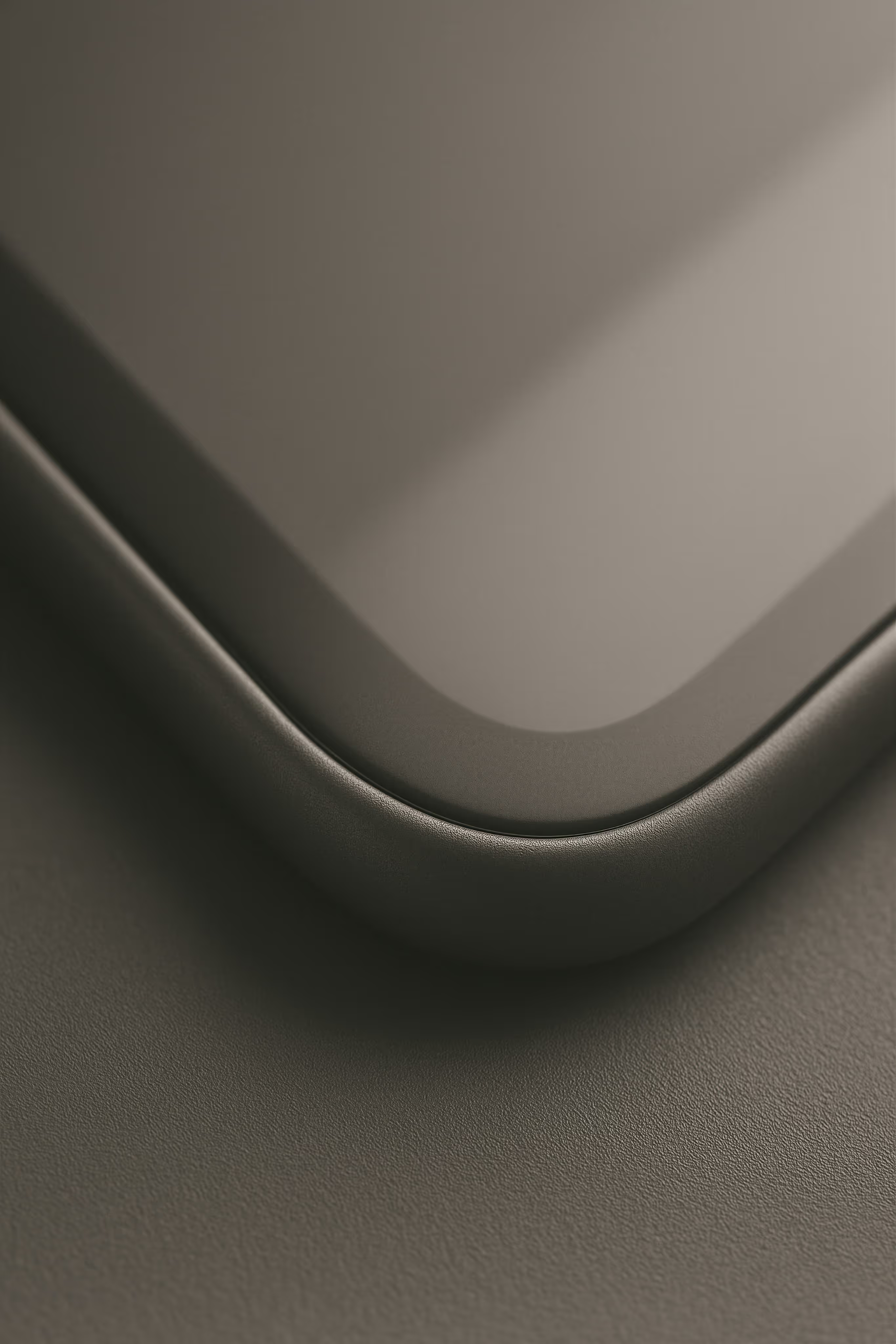 Close-up of a curved corner of a sleek, modern device with a smooth dark surface.